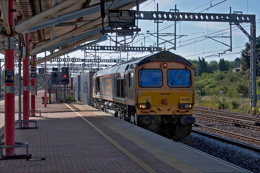 66702, 03.10 Felixstowe North-Trafford Park (4M13, 3E), Rugby station 
 66702 'Blue Lightning' brings the 4M13 03.10 Felixstowe to Trafford Park Freightliner through a very sunny and bright Rugby station. The combination of the intense summer lighting and the orientation of the running lines makes this station a tricky one in which to get decent photographs. This one needed a lot of time spent on it to make it presentable from bringing back the completely burnt-out sky to the deep shadows on the front of the train. 
 Keywords: 66702 03.10 Felixstowe North-Trafford Park 4M13 Rugby station Blue Lightning GBRF