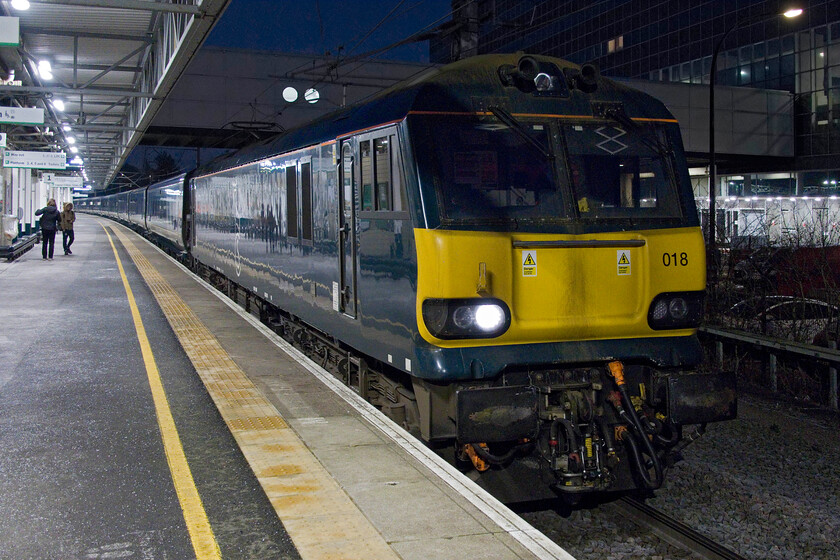 92018, CS 20.45 Inverness & 19.50 Fort William-London Euston (1M16, 40L), Milton Keynes Central station 
 Things were going wrong for up services into Euston south of Milton Keynes. All trains were being delayed including the up 1M16 Higland Caledonian Sleeper. It was held on platform one for about fifteen minutes giving Andy and me ample opportunity to cross from platform five to capture it. 92018 leads the 20.45 Inverness/19.50 Fort William sleeper during its pause. I suspect that the passengers on board appreciated the half an hour or so in bed granted to them due to its late arrival into Euston. 
 Keywords: 92018 20.45 Inverness 19.50 Fort William-London Euston 1M16 Milton Keynes Central station Caledonian Sleeper