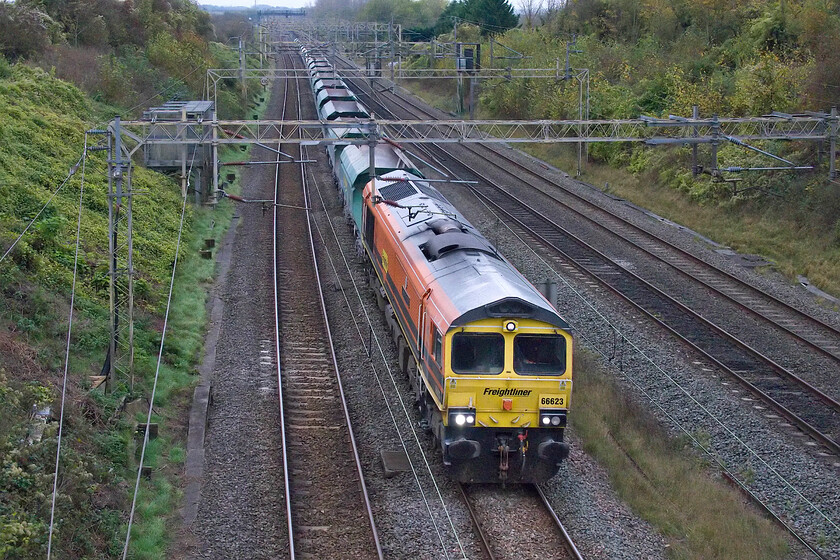 66623, 13.14 Wembley Yard-Tunstead Sidings (6H50, 45L), Victoria bridge 
 As it was so dull the camera was struggling selecting a high ISO setting (with the consequential high noise problems). To partially counteract this I selected a slightly lower shutter speed but then had to opt for a more head-on angle to avoid the worst effects of motion! 66523 'Lest We Forget' passes Victoria bridge just south of Roade leading the 13.14 Wembley Yard to Tunstead Sidings 6H60 stone empties. 
 Keywords: 66623 13.14 Wembley Yard-Tunstead Sidings 6H50 Victoria bridge Freightliner Lest we forget