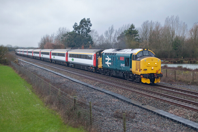 37418, outward leg of Shooter's Swansong, 09.00 Hinksey Yard-London Marylebone (1Z21, RT), Oddington SP542160 
 37418 'An Comuun Gaidhealach' passes Oddington leading the second leg of the Shooter's Swansong charter with 5008 'Thunderer' bringing up the rear. Having travelled down from Derby as the 1Z20 the train terminated past Oxford station in Hinksey Yard to then form this leg, the 1Z21 Hinksey Yard to Marylebone. Whilst conditions have improved somewhat from when I first saw the train at Heyford it was blowing an absolute hooley making it difficult to stand steadily on the exposed embankment of the bridge that crosses the line. 
 Keywords: 37418 Shooter's Swansong 09.00 Hinksey Yard-London Marylebone 1Z21 Oddington SP542160 An Comuun Gaidhealach