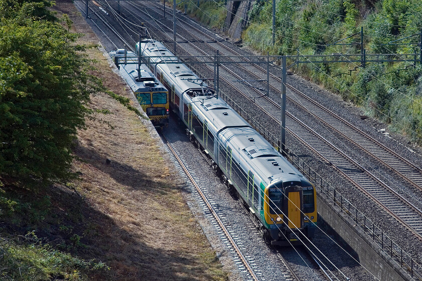 350124, LM 09.49 London Euston-Birmingham New Street & tamper, Roade cutting 
 As a track machine heads south through Roade cutting, 350124 heads north working the 09.49 Euston to Birmingham New Street train. The occupation bridge that I am standing on is not a spot that I visit very often. 
 Keywords: 350124 09.49 London Euston-Birmingham New Street tamper Roade cutting