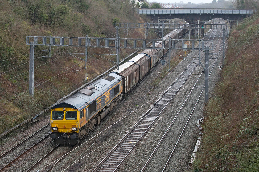 66705, 06.34 Dollands Moor-DIRFT (6M45, 1L), Hyde Road bridge 
 66705 'Golden Jubilee' passes through Roade taken from Hyde Road bridge on a particularly miserable damp day. The GBRf locomotive, which once wore a pair of huge fluttering union jacks on its flanks, is leading the bottled water train that runs as 6M45, the 06.34 Dollands Moor to Daventry. 
 Keywords: 66705 06.34 Dollands Moor-DIRFT 6M45 Hyde Road bridge GBRf water train Golden Jubilee