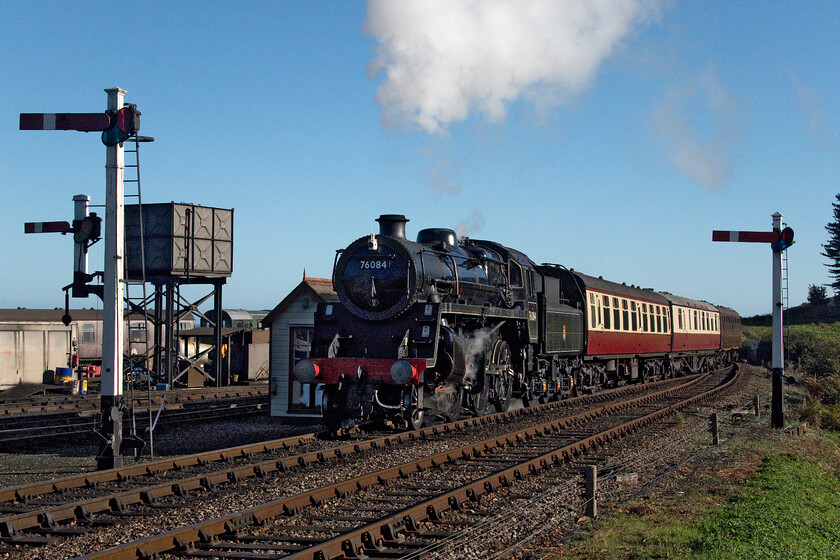 76084, 10.00 Sheringham-Holt, Weybourne station 
 Dating from 1957 and having had a mere ten years in mainline service Standard Class 4MT 76084 arrives at Weybourne station leading the 10.00 Sheringham to Holt train. It is remarkable to think that when 76084 was constructed, at a cost then of 22 000, it had a projected lifespan of forty years. This would have meant that it would have been withdrawn just three years before the Millenium in 1997! 
 Keywords: 76084 10.00 Sheringham-Holt Weybourne station Standard Class 4MT