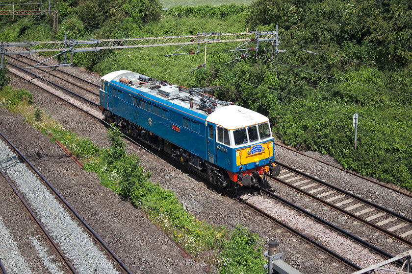 86259, 12.00 London Euston-Rugby CS LE (0Z86), Victoria Bridge 
 Still wearings its headboard from yesterday's railtour, 86259 'Les Ross' (on this side anyway!) runs as 0Z86, the 12.00 London Euston to Rugby Carriage Sidings past Victoria Bridge, near Roade, in Northamptonshire. The veteran class 86 spends its week in the overgrown sidings at Rugby awaiting its next railtour. 
 Keywords: 86259 12.00 London Euston-Rugby CS LE 0Z86 Victoria Bridge