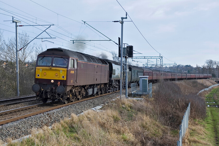 47500 & 34067, Southall-Carnforth ECS (5Z57), Wilson's Crossing 
 After being at this location for some time taking photographs in bright sunshine when the main course arrived it had clouded up! West Coast's 47500 pilots 4-6-2 unbuilt Battle of Britain 34067 'Tangmere' past Wilson's Crossing north of Northampton. The train was returning to WCR's Carnforth base from Southall following railtour duties before Christmas. Whilst Tangmere was in steam I suspect this was more for show with it providing no assistance to 47500. 
 Keywords: 47500 34067 Southall-Carnforth ECS5Z57 Wilson's Crossing WCR West Coast Railway Tangmere