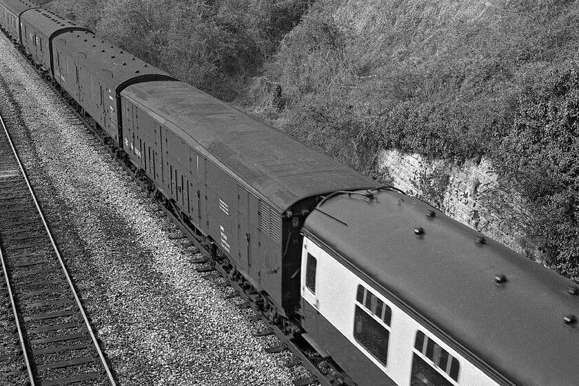 Ex GWR Siphon G & ex LMS van, up diverted vans, Avoncliff aqueduct 
 One of the thirty-four former GWR Siphon G vans converted and branded for Newspaper carriage is seen passing Avoncliff in the Avon Valley. One hundred and fifteen of this highly successful design of van were produced between 1930 and 1945 largely for the carriage of milk from all points of the GWR network either on bulk milk trains or simply attached to the rear of express services. As milk traffic declined due to road haulage they found new uses in a GUV and newspaper role such was their versatility. The last examples survived until 1985 with a small number entering preservation including one as part of the national collection at Shildon. Beyond the GUV is an LMS fifty-foot full brake van. The inclusion of these vans in the consists of a train was always easy to identify due to their protruding ducket and their three pronounced timber running boards. The story of their development and construction is an incredibly complex one with well over three hundred being produced by the LMS between 1925 and 1950 in various guises and to various specifications. The last was withdrawn from service in the early 1980s so the inclusion of one on this train in 1981 represents quite a rarity by this time; it's just a shame that I could not get its number and that of the Siphon G for that matter! 
 Keywords: Ex GWR Siphon G & ex LMS van up diverted vans Avoncliff aqueduct