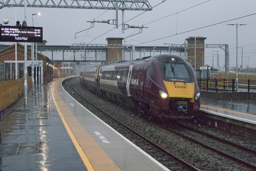 222008, EM 11.45 Nottingham-London St. Pancras (1B38, 5E), Wellingborough station 
 Taking a photograph under an umbrella in torrential rain is tricky and with lighting like this, it is even more of a technical challenge! Looking like early morning or later in the day this photograph was actually taken at 12.30! It shows 222008 at pace passing through Wellingborough station with the 11.45 Nottingham to St. Pancras service. It will not be long until yet more new trains will replace these Meridian units on this route with the completion of the electrification. Unbelievably, these units have been in operation for nearly seventeen years now; where has that time gone? 
 Keywords: 222008 11.45 Nottingham-London St. Pancras 1B38 Wellingborough station EMR East Midlands Railway