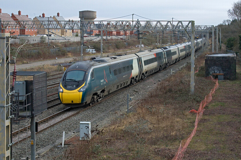 390130, VT 11.40 London Euston-Manchester Piccadilly (1H67, 2L), site of Roade station 
 390130 passes the site of Roade's former station working the 1H67 11.40 Euston to Manchester Avanti service. After a week of extremely cold weather with penetrating frosts things were very much on the turn with a warmer westerly wind blowing but one that had introduced much more cloud. 
 Keywords: 390130 11.40 London Euston-Manchester Piccadilly 1H67 site of Roade station