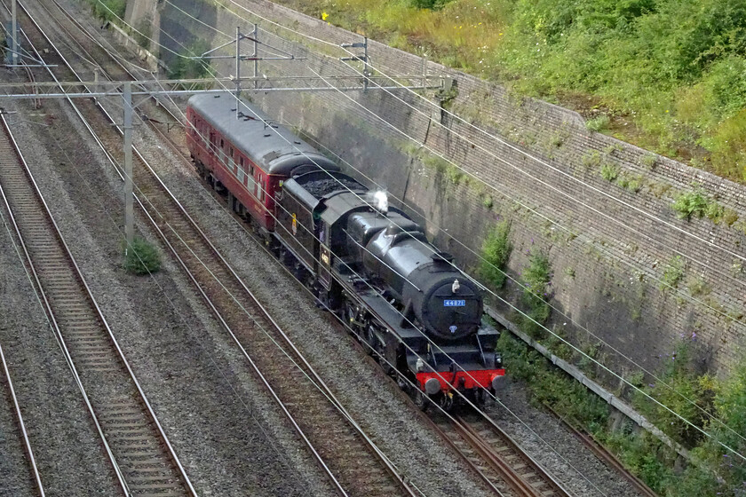 44871, 11.20 Carnforth Steamtown-Southall WCR (5V42, 42E), Roade cutting 
 Stanier Class 5 44871 leads a support coach through Roade cutting just catching a little of the late afternoon sunshine. The movement of steam locomotives for railtour duty is quite common with Carnforth and Crewe LSL being the home to many that operate in the south. In the case of the 5V42 11.20 Carnforth Steamtown to Southall WCR the locomotive will be leading the coming Saturday's West Somerset Steam Express from Paddington to Bishops Lydeard. 
 Keywords: 44871 11.20 Carnforth Steamtown-Southall WCR 5V42 Roade cutting LMS Stanier Class 5 4-6-0