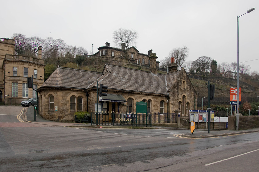 Frontage, Mossley station 
 Mossley station is an attractive building that sits high above the tracks with them passing through a short tunnel under the road to the left. The station was opened in 1849 by the London and North Western Railway.