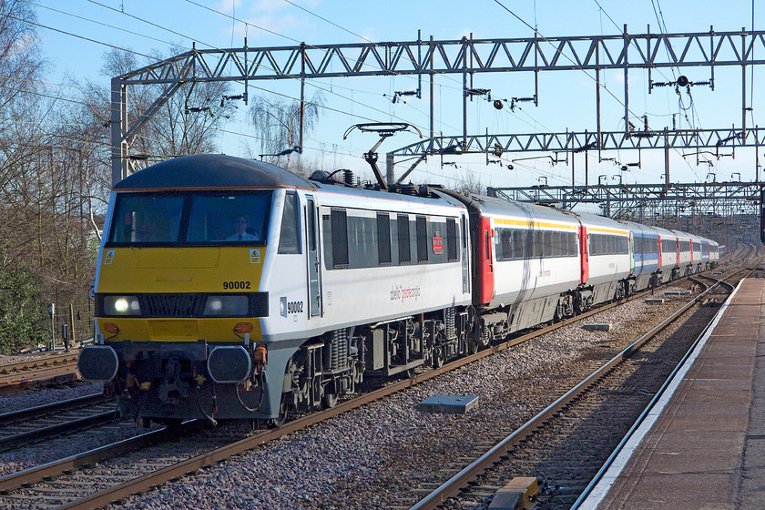 90002, LE 09.30 Norwich-London Liverpool Street (1P25), Colchester station 
 The 1P25 09.30 Norwich to Liverpool Street slows for its stop at Colchester station with 90002 'Eastern Daily Press: 1870-2010, Serving Norfolk for 140 Years' at the helm. This Abelio Greater Anglia livery looks very smart but I should imagine that it's a devil to keep looking clean and smart. Notice, the two Mk. 3 coaches spoiling the otherwise uniformed formation being in the older livery of National Express despite that now being out of operation for four years! 
 Keywords: 90002 09.30 Norwich-London Liverpool Street 1P25 Colchester station