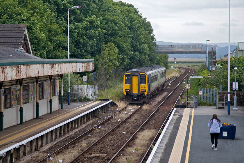 156491, NT 15.12 Carlisle-Barrow-in-Furness (2C32, 8L), Millom station 
 The 15.12 Carlisle to Barrow-in-Furness service gets away from Mllom station worked by 156491. The expanse of Duddon Bay is seen in the background beyond the bridge with fells of the Southern Lakes beyond. Notice the shabby state of the canopy of Millom station. 
 Keywords: 156491 15.12 Carlisle-Barrow-in-Furness 2C32 Millom station Northern