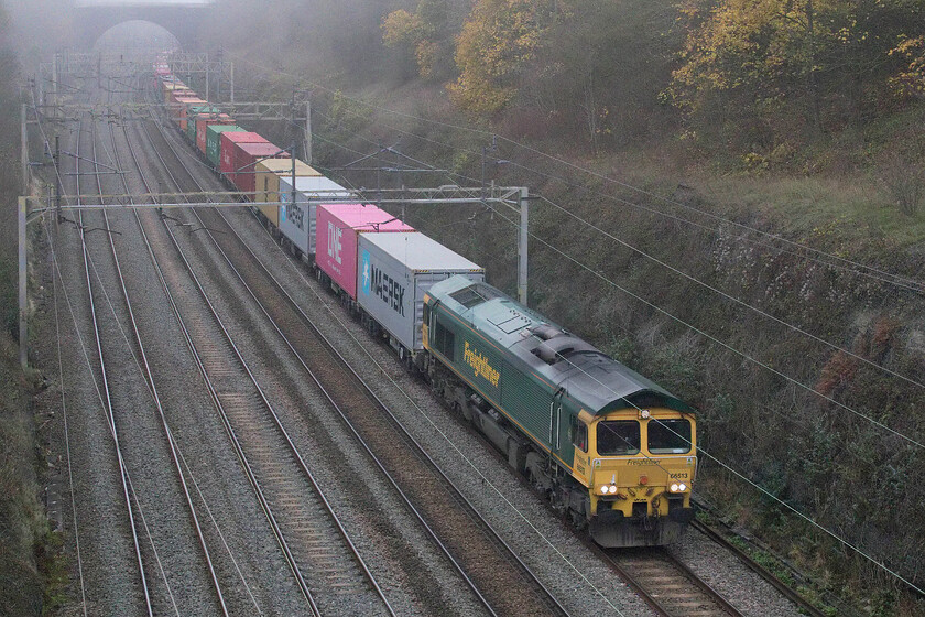 66513, 12.16 Lawley Street-London Gateway (4L46, 4E), Hyde Road bridge 
 Making very slow progress as it emerges from the foggy depths of Roade cutting 66513 leads the 12.16 Lawley Street to London Gateway Freightliner. This particular service, running as 4L46, was very well loaded on this day with the last boxes yet to pass underneath me as I walked over the bridge and away towards home and this was after I had taken a few seconds to pack my camera away and pick up my shopping bag! 
 Keywords: 66513 12.16 Lawley Street-London Gateway 4L46 Hyde Road bridge Freightliner