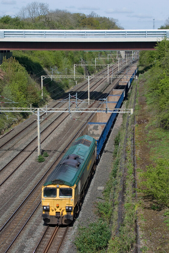 66544, 10.59 New Bilton-Willesden Euroterminal (4R98, 25E), Roade cutting 
 Following the depositing of more of HS2's huge amount of tunnelled waste in a huge former quarry just outside of Rugby the empty wagons return south again. The 4R98 10.59 New Bilton to Willesden Eusrotunnel passes through Roade cutting led by Freightliner's 66544. These trains, as seen here, are relatively short at about fifteen wagons which seems a little bit of a wasted opportunity to me, perhaps it has to do with the relatively short headshunt at New Bilton where the spoil is unloaded. Incidentally, this headshunt is the remains of the former L&NWR route to Leamington via Dunchurch and Marton Junction 
 Keywords: 66544 10.59 New Bilton-Willesden Euroterminal 4R98 Roade cutting Freightliner