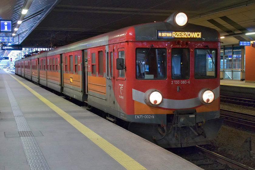 EN71-002, 17.19 Krakw Glwny-Krzeszowice (R30719), Krakw Glwny station 
 The EN71 class EMUs are four-car sets that entered service in 1965 being constructed at the Panstwowa Fabryka Wagonw (Eng. National Rail Carriage Factory) works in Breslau. EN71-002 is one of the early versions of the class having ribbed bodyside panels and is seen here at Krakw Main station working the 17.19 to Krzeszowice. Compared with PKP's modern EMU fleet, these units do look very dated with their huge searchlight front lamps. 
 Keywords: EN71-002 17.19 Krakw Glwny-Krzeszowice R30719 Krakw Glwny station