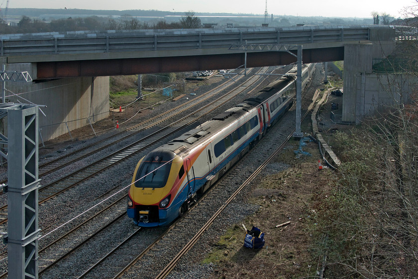 222010, EM 12.31 London St. Pancras-Sheffield (1F32, 4L), Mill Road bridge 
 This view from Wellingborough's Mill Road bridge used to be so much better! Firstly, prior to the construction of the Driver Way bridge, this angle showed the station and its environs. Secondly, huge and unsightly anti-suicide panels have been fixed to the top of the brick parapets of the Mill Road bridge thus making photography very tricky without the use of a step ladder. To take this photograph, I have held the camera at fully stretched arm's length above my head, utilising the flip-out screen to sight the train. 222010 heads north with the 1F32 12.31 St. Pancras to Sheffield service. 
 Keywords: 222010 12.31 London St. Pancras-Sheffield 1F32 Mill Road bridge EMR East Midlands Railway Meridian