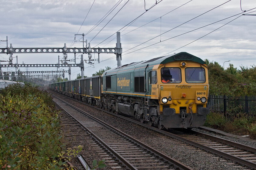 66616, 13.23 Wembley Reception-East Usk Yard (6V18, 15L), Didcot Parkway station 
 Unusually the 13.23 Wembley Yard to East Usk Yard empty stone working was pathed on the down fast line through Didcot and beyond. 66616 was working well hauling the 6V18 keeping up to its permitted speed and was about to pass the looped 6B11 (also heading for East Usk Yard) to the west of the station. I did not follow the progress of 6V18 so I am not sure how long it remained on the fast line but hopefully for fare-paying passengers not for enough time to hold up GWR IETs breathing down its tail light! 
 Keywords: 66616 13.23 Wembley Reception-East Usk Yard 6V18 Didcot Parkway station Freightliner