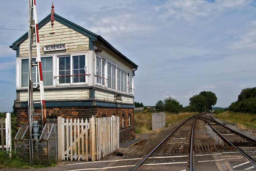 Alrewas signal box & level crossing (L&NWR, 1899) 
 A view looking northeast from Alrewas level crossing with the signal box that controls it to the immediate left. Behind me lies the five miles or so of double track to Lichfield Trent Valley, a section of track only frequented by a few daily freight workings. The double-track becomes just a single just beyond the box with that joining the Midland Birmingham to Derby route just around the curve in the distance at Wichnor Junction. Unlike Lichfield Trent Valley signal box that I saw a little earlier in the afternoon, it looks as though Alrewas box needs a visit from the maintenance team! 
 Keywords: Alrewas signal box & level crossing