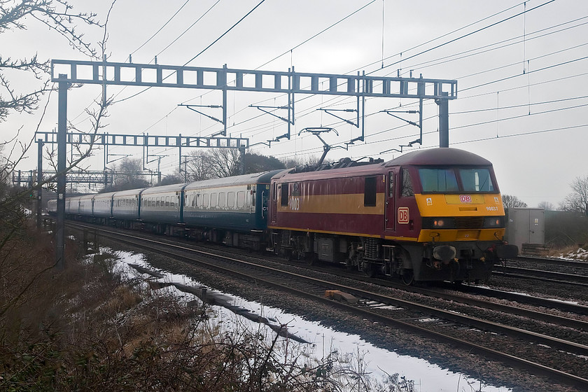 90037, 10.28 London Euston-Manchester Footex (1Z61), Ashton Road Bridge 
 90037 'Spirit of Dagenham' approaches Roade on the WCML down slow with the classic rake of Riviera Trains Mk2s in tow working the 10.28 London Euston to Manchester Piccadilly football charter. It was conveying Chelsea fans to their match with Manchester City. Unfortunately, they would return later in the day disappointed with their 1-0 defeat. I hope that the chance to travel in this superb rake of refurbished Mk. 2 coaches cheered them up a bit! 
 Keywords: 90037 10.28 London Euston Manchester Footex 1Z61 Ashton Road Bridge