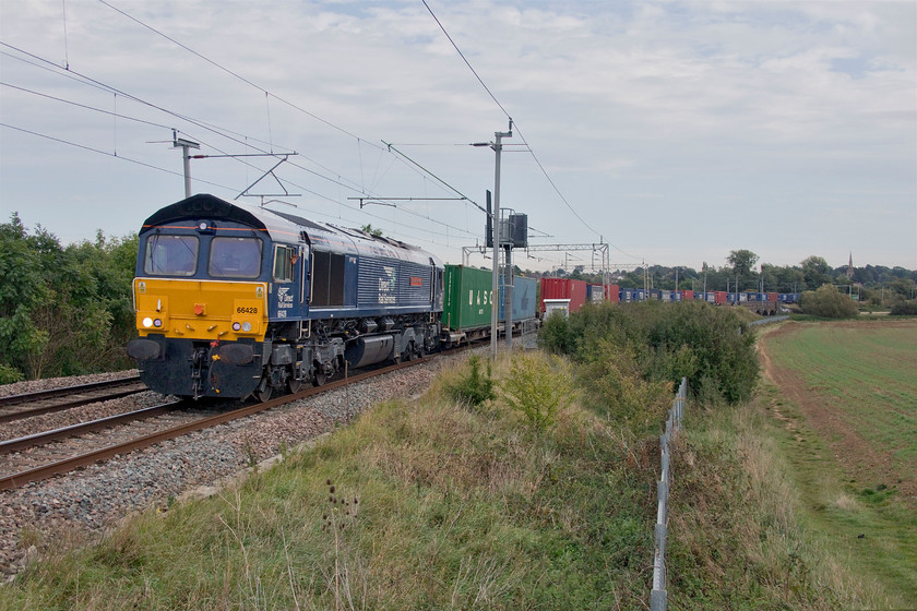 66428, 09.55 Tilbury-DIRFT (4M07, 1L), Wilson's Crossing 
 Fast becoming one of my most recently photographed Class 66s 66428 'Carlisle Eden Mind' heads north away from Northampton with the 09.55 Tilbury to Daventry Tesco Express working. I saw the same 66 working north the previous aftenoon, see....https://www.ontheupfast.com/p/21936chg/29616581404/x66428-11-05-tilbury-dirft-42l-site so DRS are obviously getting the best value from their locomotives by working them pretty intensively. Notice the cheery wave from the driver directed towards the small gathering of enthusiasts at this popular spot. 
 Keywords: 66428 09.55 Tilbury-DIRFT 4M07 Wilson's Crossing DRS Direct Rail Sevices Carlisle Eden Mind