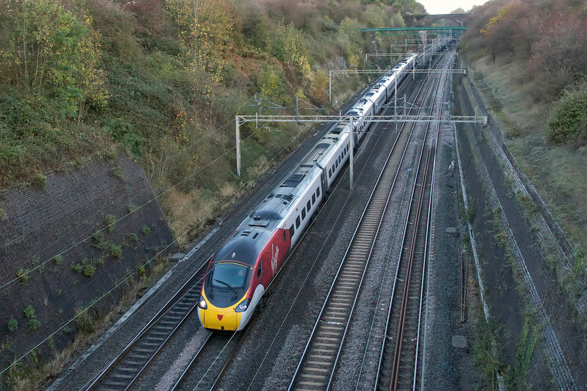 390045, VT 12.55 Manchester Piccadilly-London Euston (1A31, RT), Roade Cutting 
 390045 'Virgin Pride' passes through Roade Cutting with the 12.55 Manchester to Euston. In its new flying silk livery, it certainly brightens up the rather dingy depths of the cutting. 
 Keywords: 390045 12.55 Manchester Piccadilly-London Euston 1A31Roade Cutting