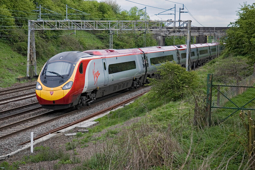 390006, VT 17.00 London Euston-Manchester Piccadilly, Roade 
 The Virgin Trains 17.00 London Euston to Manchester Piccadilly approaches Roade worked by 390006. Contrary to what the photograph appears to show, I am on the 'right side' of the fence with it running along the bottom of the bank if rather overgrown! 
 Keywords: 390006 17.00 London Euston-Manchester Piccadilly Roade Virgin Trains Pendolino