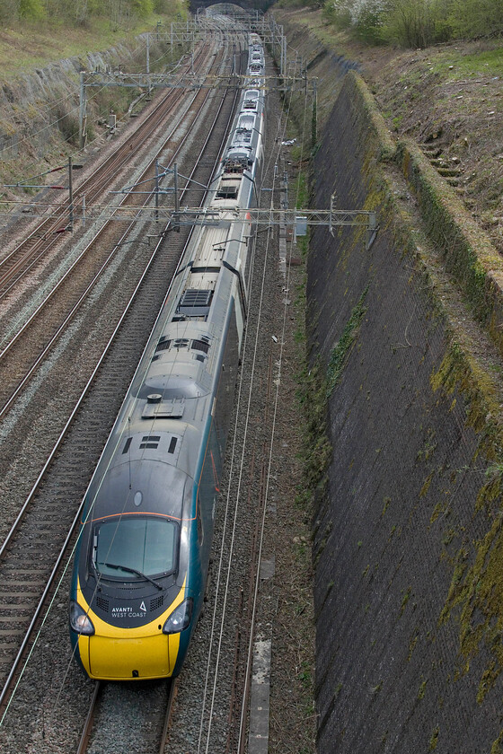 390123, 14.29 London Euston-Carlisle (1S72, 3L), Roade cutting 
 390123 passes northwards through Roade cutting working Avantis 1S72 14.29 Euston to Carlisle. This service has an interesting stopping pattern running non-stop to Warrington (one hundred and eight two minutes) then calling at every station to its destination apart from Leyland. 390123 was the second set of the refurbishment programme to re-enter service in May 2022. To date, I have yet to travel on one of the new look Pendolinos. 
 Keywords: 390123 14.29 London Euston-Carlisle 1S72 Roade cutting AWV Avanti West Coast Pendolino