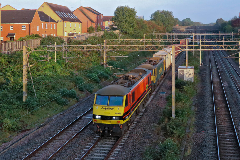 90005 & 90042, 04.57 Trafford Park-Ipswich SS (4L97, 20L), site of Roade station 
 Just catching some early morning September sunshine as it emerges from Roade cutting the 04.57 Trafford Park to Ipswich SS is seen hauled by Freightliner 90005 and 90042. The train is on the up fast line thus avoiding Northampton due to this day being another in a long line of strike days blighting our beleaguered railways; come along unions and employers, talk for goodness sake. The train will run to Ipswich using AC power to then be hauled down to Felixstowe probably by a Class 66. As an aside, can anybody out there please tell me what the SS stands for as in Ipswich SS? 
 Keywords: 90005 90042 04.57 Trafford Park-Ipswich SS 4L97 site of Roade station Freightliner