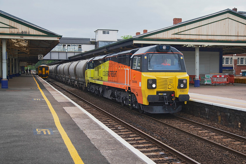 150239, GW 13.43 Plymouth-Newton Abbot (2A63, RT) & 70817, 11.38 Moorswater-Aberthaw (6C36), Newton Abbot station 
 70817 brings and blast of colour to an otherwise drab summer's day as it passes through Newton Abbot at some speed with the 11.38 Moorswater to Aberthaw cement tank empties. This is regular twice weekly working that we were keen to see given the dearth of freight on the south west peninsular. 150239 waits at platform two having arrived from Plymouth and terminated. 
 Keywords: 150239 2A63 70817 11.38 Moorswater-Aberthaw 6C36 Newton Abbot station