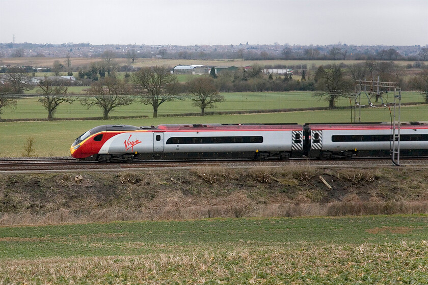 Class 390, 07.30 London Euston-Glasgow Central, Blisworth 
 Normally, the outward Cumbrian Mountain Express follows this Virgin service, the 07.30. Euston to Glasgow service, after both trains reach Milton Keynes. However, something went wrong today with the charter held at Milton Keynes Central for an unspecified reason for a long enough time that I had to head off for a prior appointment. Evidently, it did pass this spot at Blisworth near Northampton some fifteen minutes after I left for the car. Notice the camber of the track at this location and the Pendolino doing what it does so well, tilting in order to make best use of that camber. 
 Keywords: Class 390 07.30 London Euston-Glasgow Central Blisworth Virgin Pendolino