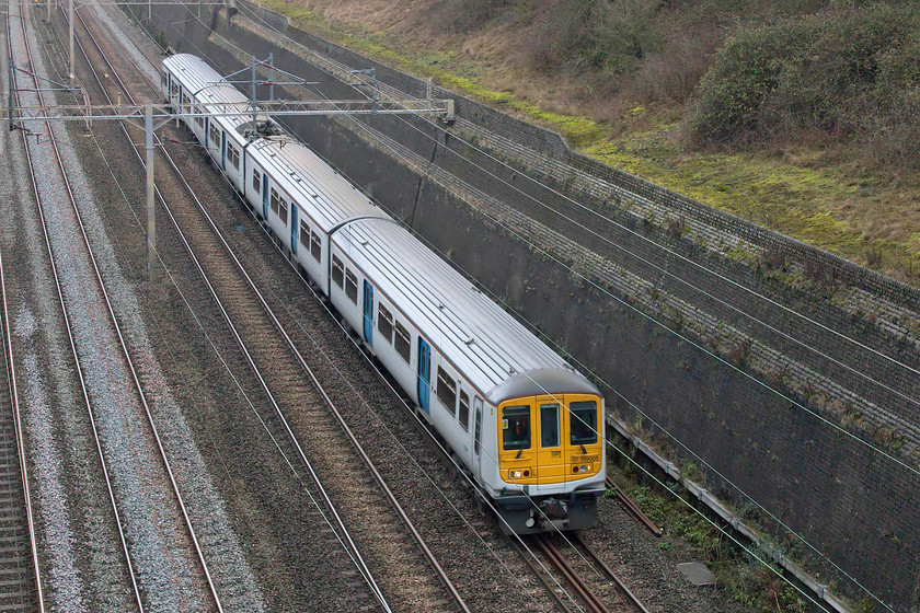 319005, 12.17 Northampton-Bletchley TMD (5B01, 17L), Roade cutting 
 And so we come to my final photograph of 2020 - let's draw a line under it and move on to 2021!

It shows the 12.17 Northampton to Bletchley empty coaching stock 5B01 move passing through Roade cutting. London Northwestern still maintains a small fleet of Class 319s to supplement its operations but with hardly any commuter traffic now taking place the necessity of keeping them operational is surely in question? Still wearing its Thameslink white and light blue colourings 319005 dates from 1987 and was built by BREL at York and like so many units of the time was built around a Mk.III coach.

A happy New Year to all my readers; here's to a far better 2021! 
 Keywords: 319005 12.17 Northampton-Bletchley TMD 5B01 Roade cutting London Northwestern