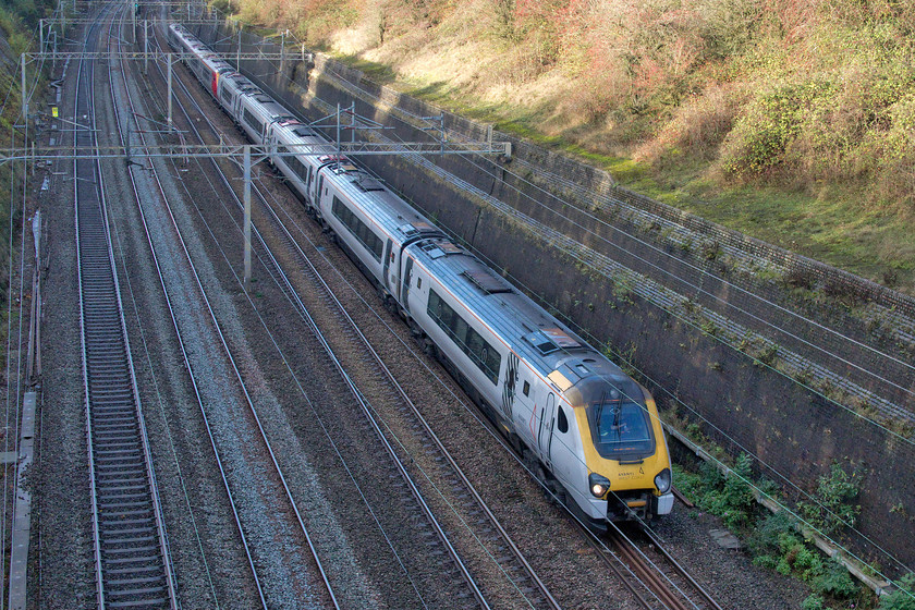 221101 & Class 221, VT 12.50 Birmingham New Street-London Euston (1B21, 44L), Roade cutting 
 Unfortunately, by this time of day during British wintertime the sun, when it's out, does not illuminate the depths of Roade cutting making photography tricky. Celebrity Voyager 221101 '101 Squadron' leads another, but unidentified, set through the cutting working the very late running and diverted 12.50 Birmingham New Street to Euston train. With Avanti West Coast putting on hold its plans to introduce new bi-mode units to replace the Voyagers it looks as though the WCML will be stuck with them for a little longer yet! 
 Keywords: 221101 Class 221 VT 12.50 Birmingham New Street-London Euston 1B21 Roade cutting Voyager Avanti West Coast 101 Squadron