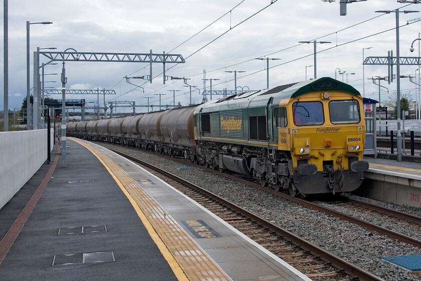 66604, 11.10 Theale Lafarge-Hope Earles Sidings (6M91, 2L), Wellingborough station 
 It was worth the ten-minute wait at Wellingborough station to capture the passage of the 6M91 11.10 Theale to Hope empty cement train as 66604 was a photographic cop! It was just beginning to pick up speed after being checked by a northbound EMR service as it needed to pass from the down slow to the fast at Harrowden Junction a short distance north of Wellingborough. 
 Keywords: 66604 11.10 Theale Lafarge-Hope Earles Sidings 6M91 Wellingborough station Freightliner