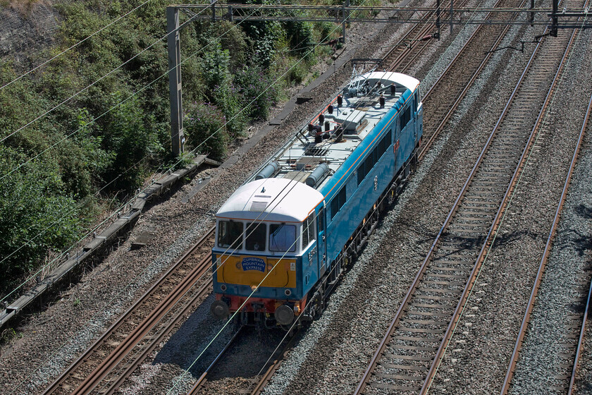 86259, 12.04 London Euston-Rugby CS (0Z86, 6E), Roade cutting 
 This time on the down slow taking it via Northampton 86259 'Les Ross/Peter Pan' passes through Roade cutting as the 0Z86 12.04 London Euston to Rugby carriage sidings. This light engine move follows from it hauling the Cumbrian Mountain Express yesterday the headboard from which still adorns the front of the locomotive. As E3137, 86045 and latterly 86259 I wonder how many times it passed this spot from its introduction to service in 1966 until withdrawal prior to restoration in 2003? 
 Keywords: 86259 12.04 London Euston-Rugby Carriage sidings 0Z86 Roade cutting Peter Pan Les Ross