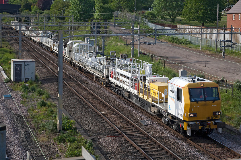 DR98003, DR98004, DR98011 & DR98009, 14.48 Crewe TMD-London Euston terminated at Bletchley (63L), site of Roade station 
 A line of Network Rail YXA Electrification MPVs led by DR98003 passes Roade. However, things were about to go badly wrong for this 14.48 Crewe to Euston working as it was to fail just three miles from here at Hanslope Junction. It blocked the up slow line for quite some time before proceeding to Bletchley where it was put in a siding and stopped. I am not sure if it restarted and moved under its own power or if it was rescued by another locomotive? 
 Keywords: DR98003 DR98004 DR98011 DR98009 14.48 Crewe TMD-London Euston terminated at Bletchley (63L), site of Roade station