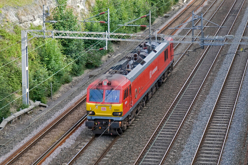 92031, down LE to DIRFT for 18.39 DIRFT-Coatbridge (4M97), Roade cutting 
 Class 92s have become increasingly rare on the southern section of the WCML in recent years. They still do put in appearances with this one running light engine from Wembley Yard to Daventry's rail freight terminal. Later in the evening, it would work the 4M97 DIRFT to Coatbridge service. I think that the DB livery as applied to this example looks very smart and suits the locomotive. 
 Keywords: 92031 DIRFT 18.39 DIRFT-Coatbridge 4M97 Roade cutting light engine