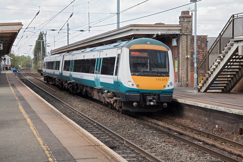 170272, GA 13.50 Peterbrough-Ipswich (2L77,1E), Stowmarket station 
 Still wearing Greater Anglia teal green and white livery, 170272 arrives into Stowmarket station working the 13.50 Peterborough to Ipswich. Stowmarket crossing box can be seen in the distance on Station Road East where the barriers have already been raised and cars crossing. 
 Keywords: 170272 2L77 Stowmarket station