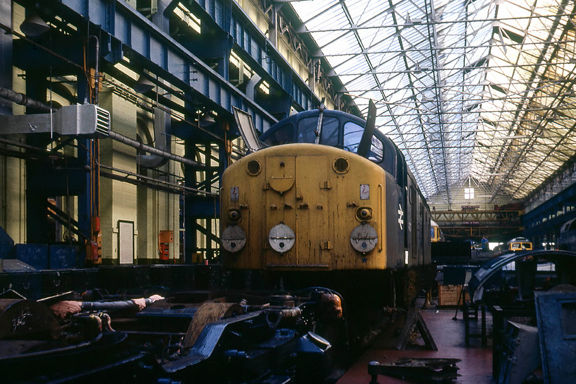 40027, 47708 & 47204, undergoing repairs, Crewe Works 
 In my notes, I have this down as 40027 formally named 'Parthia' at Crewe Works. Indeed, it was at the works during this time having arrived on 10.05.79 after sustaining accident damage. But, in this image, it looks like it is undergoing an overhaul rather than having accident damage rectified. However, a close examination of the bodyside reveals the rivets clearly in place that would have held the nameplate and crest so it was one of the named class 40s. Of the twenty-four named examples, 40027 was one of the three on the works during this time, so it could be as per my original notes....can anybody help? Behind the 40 is a silver-roofed 47 that I have in my notes as 47708 'Waverley' and on the far side 47204, a local Crewe Diesel locomotive. 
 Keywords: 40027, 47708 & 47204, undergoing repairs, Crewe Works