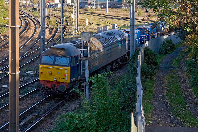 57009, unidentified up RHTT, Thorpe Junction 
 57009 brings up the rear of a mysterious RHT train at Thorpe Junction immediately southeast of Norwich station. With nothing showing on RTT I presume that the out of service train was heading back to its base at Stowmarket. 57009 was one of the twelve Class 57 converted between 1997 and 1999 for use by Freightliner as a stopgap prior to the introduction of the Class 66s. When in service with the freight operator in their green livery it was named 'Freightliner Venturer'. Prior to its conversion, it was numbered 47079 'George Jackson Churchward' that I enjoyed haulage behind way back in 1977, see.... https://www.ontheupfast.com/p/21936chg/23615805204/having-pulled-into-platform-15-york 
 Keywords: 57009 RHTT Thorpe Junction DRS Direct Rail services Crown Point