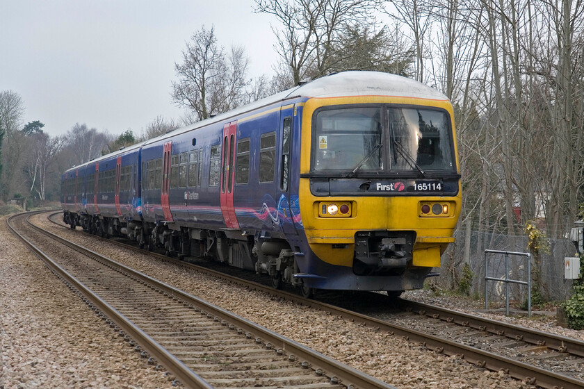 165114, GW 08.20 Reading-Shalford, Sandhurst station 
 The first photograph of our trip to the southern counties finds us at a grey and dull Sandhurst station. First Great Western's 165114 arrives working the 08.20 Reading to Shalford (via Guildford) service. More usually expected to be found around Bristol or Westbury this Turbo unit is very much operating in an outpost of the FGW network operating deep into Surrey. 
 Keywords: 165114 08.20 Reading-Shalford Sandhurst station FGW First Great Western