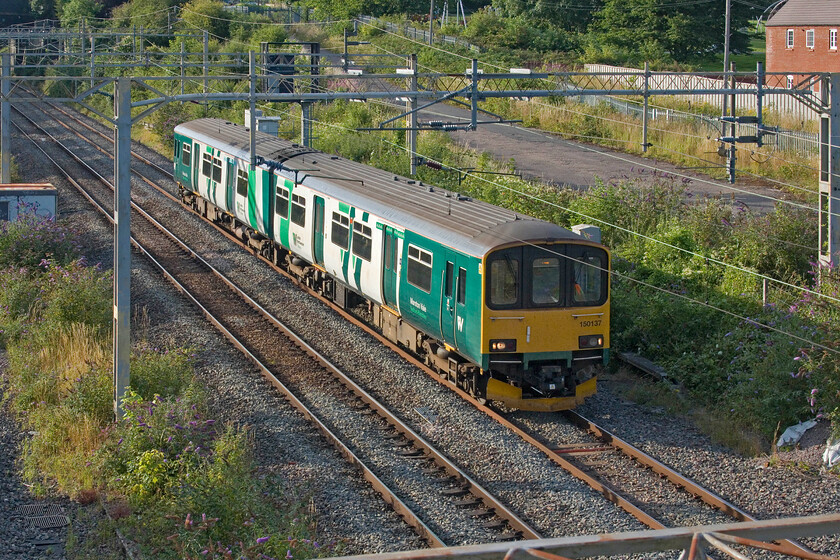 150137, 15.36 Newton Heath-Bletchley TMD (5Z51, 19E), site of Roade station 
 Since the reintroduction of the Class 150s on the Marston Vale line between Bletchley and Bedford the units have been 'borrowed' from Northern. Whilst they have been re-branded they still appear to be having to go to and from Newton Heath for weekly servicing and exams. In past years this work was undertaken by Soho and there are still paths for this so perhaps this example is just a unit swap. Either way, it's a poor state of affairs when a railway cannot provide and maintain some units for a local service close to where it works. 150137 is seen passing Roade as the 5Z51 15.36 Newton Heath to Bletchley TMD. 
 Keywords: 150137 15.36 Newton Heath-Bletchley TMD 5Z51 site of Roade station