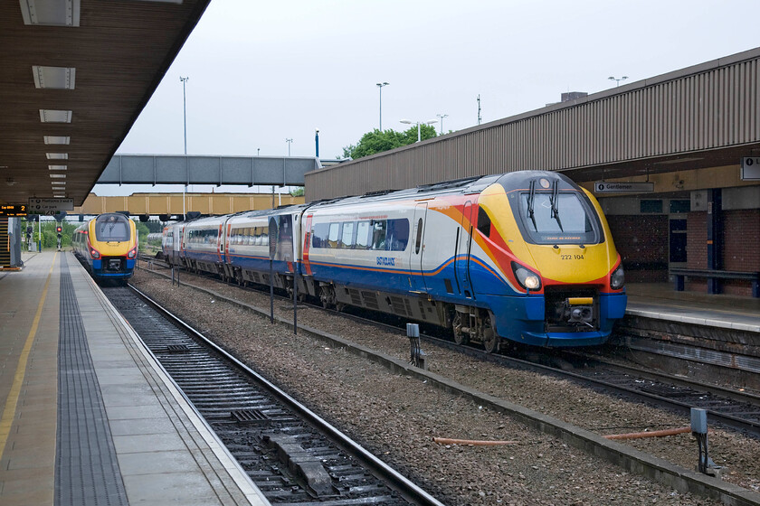 222018, EM 08.30 London St. Pancras-Nottingham (1D14) & 222104, EM 08.49 Sheffield-London St. Pancras (1C27), Leicester station 
 Leicester station (formally Known as 'Midland') is a shadow of its former self. It once boasted an overall roof and station buildings all designed by the renowned architect Charles Trubshaw who did a lot of work for the Midland Railway. This was all swept away, save for the grand frontage on London Road, by BR in 1978 when it was replaced by this rather utilitarian structure that remains very much of its time. As 222018 leaves with the 08.30 St. Pancras to Nottingham, 222104 arrives with the 08.49 Sheffield to London service. 
 Keywords: 222018 08.30 London St. Pancras-Nottingham 1D14 222104 08.49 Sheffield-London St. Pancras 1C27 Leicester station EMT East Midlands Trains Meridian