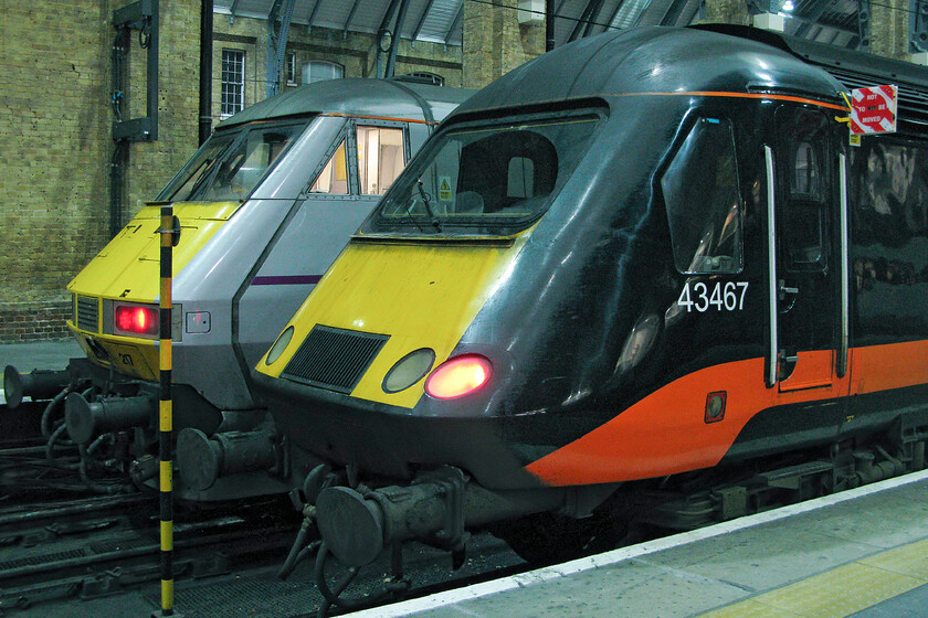 82217, GR 21.17 London King's Cross-Bounds Green ECS (5Y23) & 43467, GC 17.29 Sunderland-London King's Cross, London King's Cross station 
 Two very different machines stand on the blocks at King's Cross on this dark and chilly Saturday night. To the left National Express DVT 82217 will soon depart the short distance to Bounds Green depot at the rear of the 5Y23 empty coaching stock working whilst HST power car 43467 has recently arrived leading Grand Central's 17.29 from Sunderland. 
 Keywords: 82217 21.17 London King's Cross-Bounds Green ECS 5Y23 43467 17.29 Sunderland-London King's Cross London King's Cross station East Coast National Express Grand Central