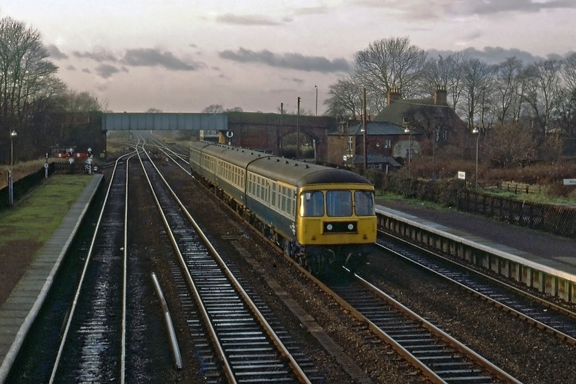 Class 124 DMU, 14.12 Leeds-Hull, Gilberdyke station 
 A Class 124 DMU passes at speed through Gilberdyke station working the 14.12 Leeds to Hull service. These were felt by many to be amongst the finest of the first generation DMUs being built almost entirely around a Mk. I coach with powerful engines under, initially at least, every coach, a unique feature at the time. With their curved windscreens, they also looked the part and had a successful career spanning some twenty-four years; yet another Swindon success story! 
 Keywords: Class 124 DMU 14.12 Leeds-Hull Gilberdyke station