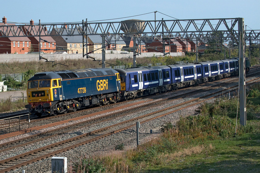 47739, 360113 & 47727, 11.52 Ilford EMUD-Northampton EMD (5Q60, 13L), site of Roade station 
 In a repeat operation, another former Greater Anglia Class 360 is dragged from Ilford to Northampton's Siemen's facility for modification enabling it to operate at up to one hundred and ten miles per hour. This work, that I suspect is largely software related, means that it is one of the units targeted to operate on the yet to be energised and tested MML between St. Pancras and Corby. At the site of Roade's former station, 47739 leads the train at a very slow speed with 47727 'Edinburgh Castle/Caisteal Dhun Eideann' at the rear. In common with the other times that this operation has taken place, the train is often fairly early prompting me to get out to my chosen spot only for control to hold it to its booked time by sidelining it at Bletchley and then holding it at Milton Keynes leading to a frustrating wait for me! 
 Keywords: 47739 360113 & 47727, 11.52 Ilford EMUD-Northampton EMD (5Q60, 13L), site of Roade station GBRF Edinburgh Castle Caisteal Dhun Eideann GBRf