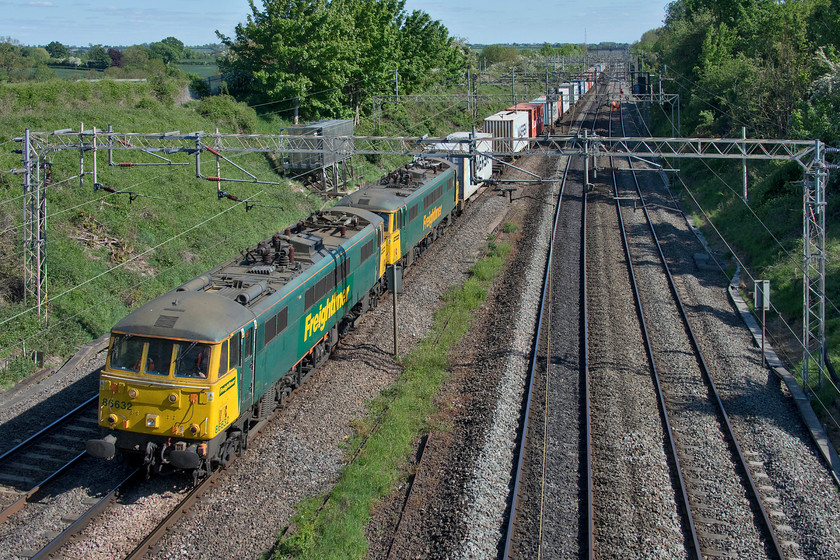 86632 & 86639, 11.13 Felixstowe North-Trafford Park (4M87, 23E), Victoria bridge 
 With the arrival at Freightliner's Crewe Basford Hall headquarters of a number of ex Greater Anglia Class 90s the use of the vintage AL6 Class 86s is now on borrowed time. The plan is for the new locomotives to be in operation by July but with COVID-19 delays, this date may well be pushed back. In light of this, I take every opportunity to capture their workings in what is the twilight of their working career. 86632 (built in April 1966) and 86639 (05.66) lead the 11.13 Felixstowe to Trafford Park 4M87 Freightliner past Victoria bridge south of Roade. 
 Keywords: 86632 86639 11.13 Felixstowe North-Trafford Park 4M87 Victoria bridge Freightliner AL6