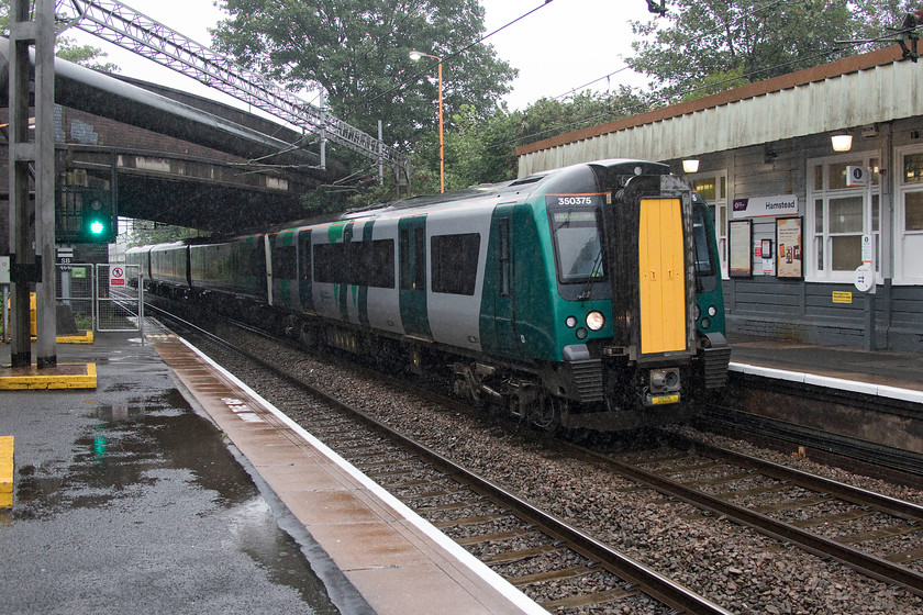 350375, LN 12.01 Walsall-Wolverhampton (2W26, 4L), Hamstead station 
 Yes, it's still teeming with rain! 350375 'Vic Hall' arrives into Hamstead station working the 12.01 Walsall to Wolverhampton service. This class 350 was named at Watford Junction ten days previously to celebrate the retirement, after fifty years of service, of career railwayman Vic Hall, see.... https://www.watfordobserver.co.uk/news/17829774.train-named-iconic-railwayman/ 
 Keywords: 350375 12.01 Walsall-Wolverhampton 2W26 Hamstead station