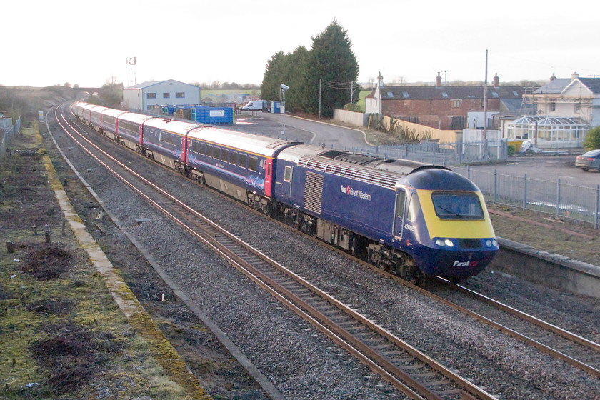 43005, GW 13.28 Swansea-London Paddington (1L66), site of Shrivenham station 
 43005 leads the 13.28 Swansea to Paddington past the former platforms of Shrivenham station in Wiltshire. Close examination of the image reveals that the driver is waving to me as I stand on the road bridge in the late afternoon with the sun having just set. 43005 is one of the earliest production power cars being part of Western Region set 253002, one that I first saw as a young spotter in 1976. Thirty-nine years later, it is still doing what it was designed to do but its time is limited as the electrification will bring an end to its use. 
 Keywords: 43005 13.28 Swansea-London Paddington 1L66 site of Shrivenham station