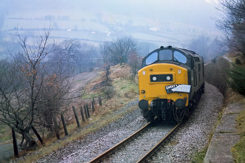 37233 & 37269, outward leg of The Gwent Valley Invader, Crewe-Blaenavon (1Z46), Pentre Piod Halt SO263019 
 For some reason, we did not follow the train on its journey up to Ebbw Vale. Instead, we planned to chase it while it climbed up towards Blaenavon. This was an incredibly circuitous route that wound its way steeply up the valley from Pontypool. Graham had figured that we ought to be able to see it three times during this part of its journey. Here, 37233 and 37269 bring the railtour round a steeply graded 180 curve near to the remains of Pentre-Piod Halt at OS grid reference SO263019. 40120 was supposed to have worked up the valley with a 37 assisting. But, for some reason, control at Newport decreed that it had to be two 37s, that was a bit of disappointment. This spot is now devoid of track as this coal mines closed in the early 1980s However, this dramatic section of railway can still be enjoyed on a bike as National Cycle Network route 492 starting at Cwmbran and finishing at Brynmawr going via Blaenavon. 
 Keywords: 37233 37269 The Gwent Valley Invader Crewe-Blaenavon 1Z46 Pentre Piod Halt SO263019