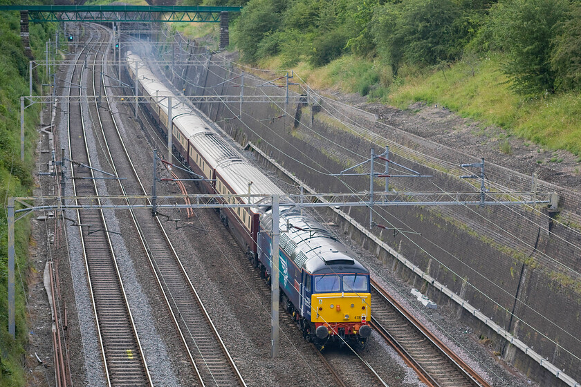 47810, return leg of The Northern Belle, 17.38 Kensington Olympia-Liverpool Lime Street (1Z53), Roade cutting 
 The returning 17.38 Kensington Olympia to Liverpool Lime Street Northern Belle charter passes through Roade cutting. With 47790 'Galloway Princess' opening up at the front of the train and creating a smokescreen 47810 'Peter Bath MBE' is dragged along at the rear dead in tow. If anybody can enlighten me as to why this train ran please get in contact as there appear to be no contemporary records. 
 Keywords: 47810 The Northern Belle, 17.38 Kensington Olympia-Liverpool Lime Street 1Z53 Roade cutting Peter Bath MBE